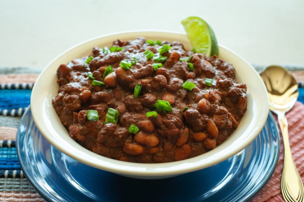 Chocolate Chili with Chipotle Peppers garnished with green onions and a lime wedge