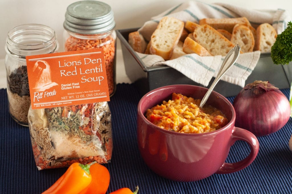 Lion's Den Red Lentil Soup next to artisan bread and other ingredients.